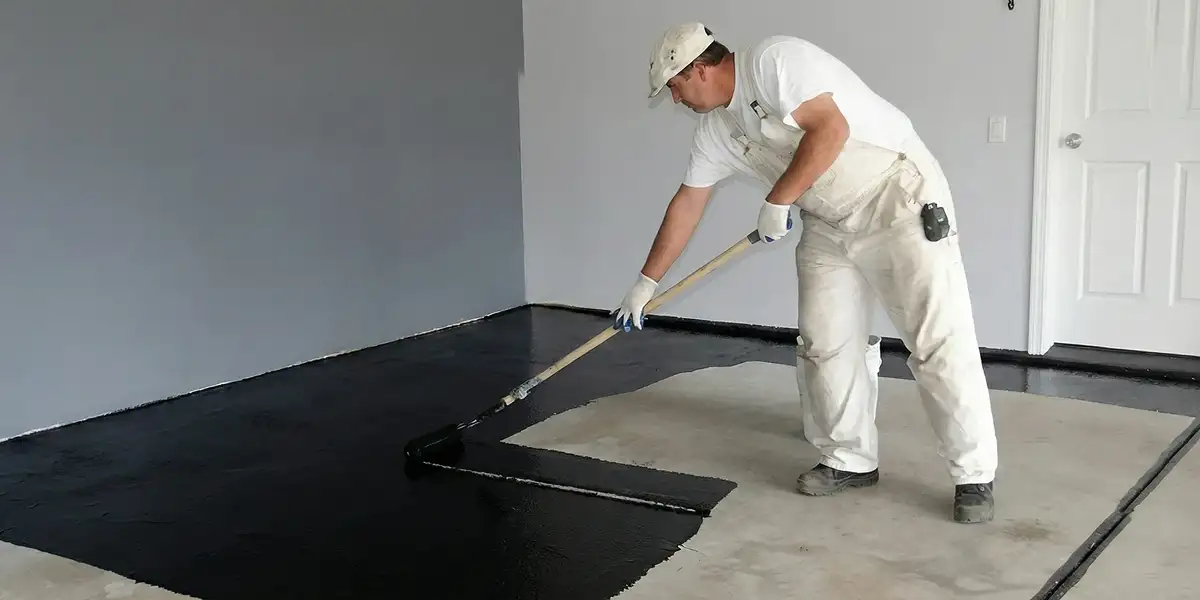 basement waterproofing professional applying waterproof coating to protect a basement floor in Boise, ID